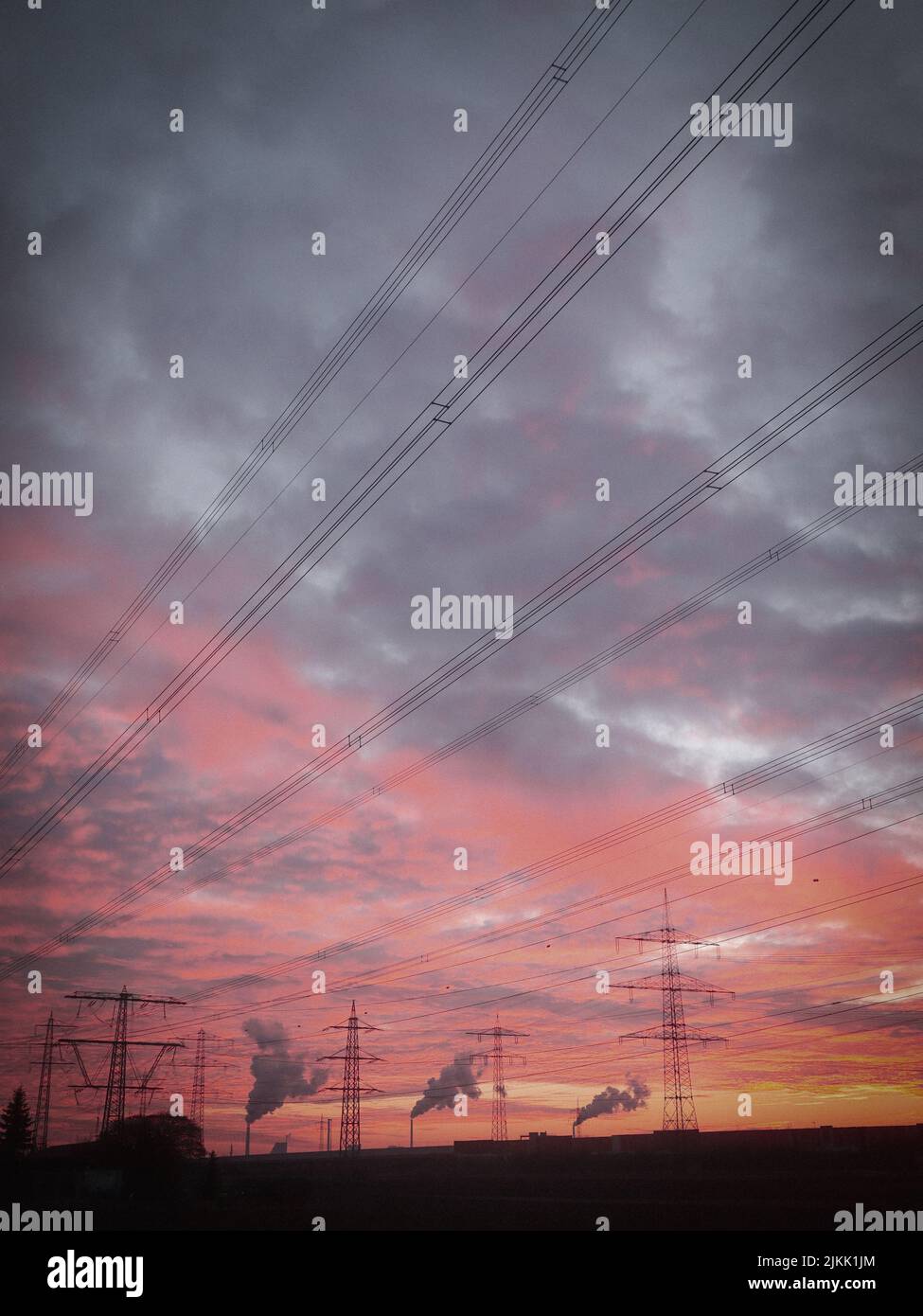 The power lines and electrical pylons against a cloudy sunset sky Stock ...