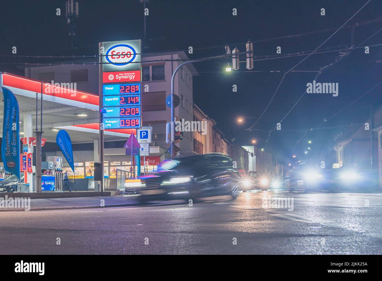 A shot of Esso gas station illuminated by traffic lights at night in Heidelberg, Germany Stock Photo