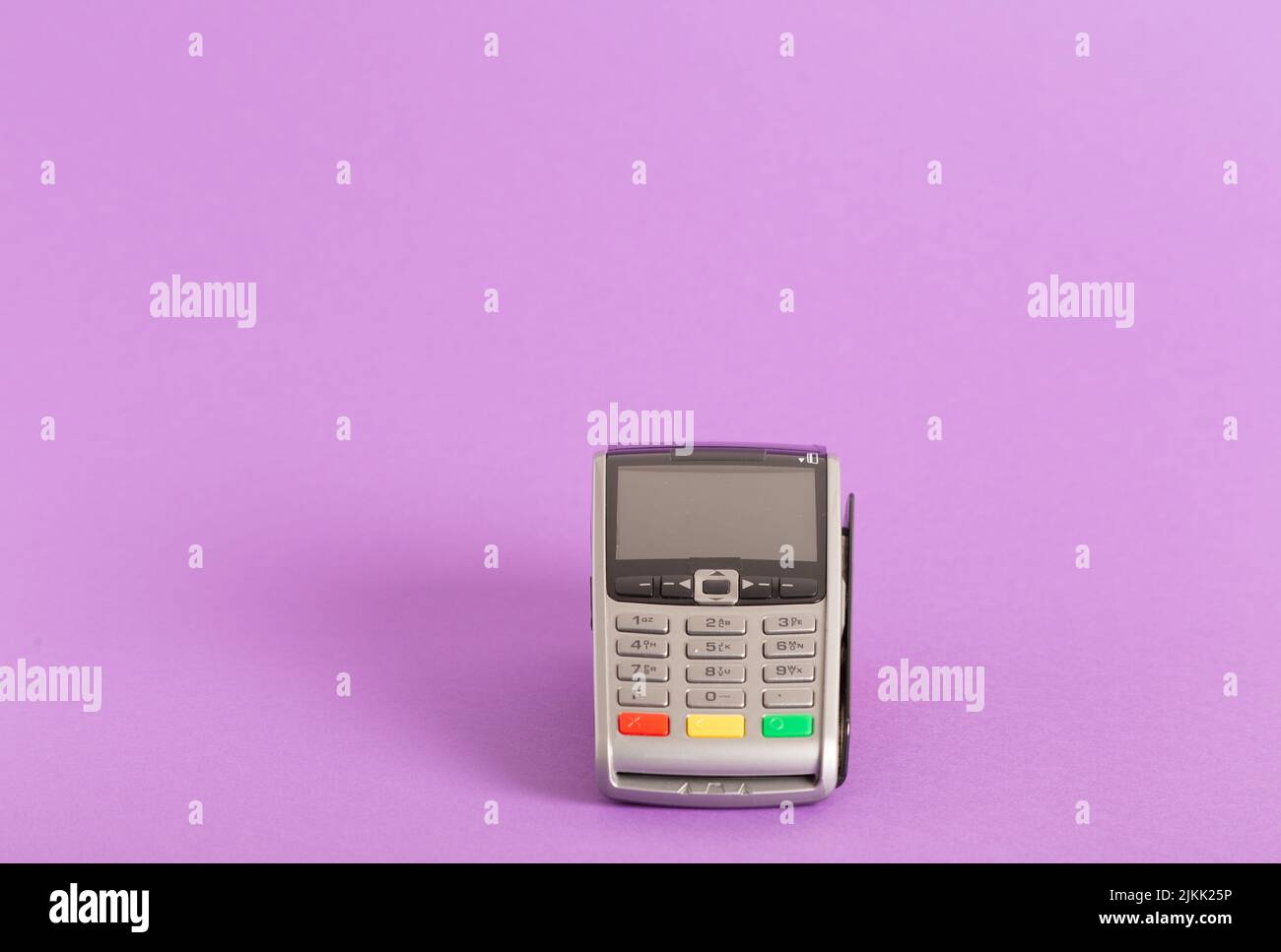 A closeup shot of the POS terminal credit card machine on a pink background Stock Photo