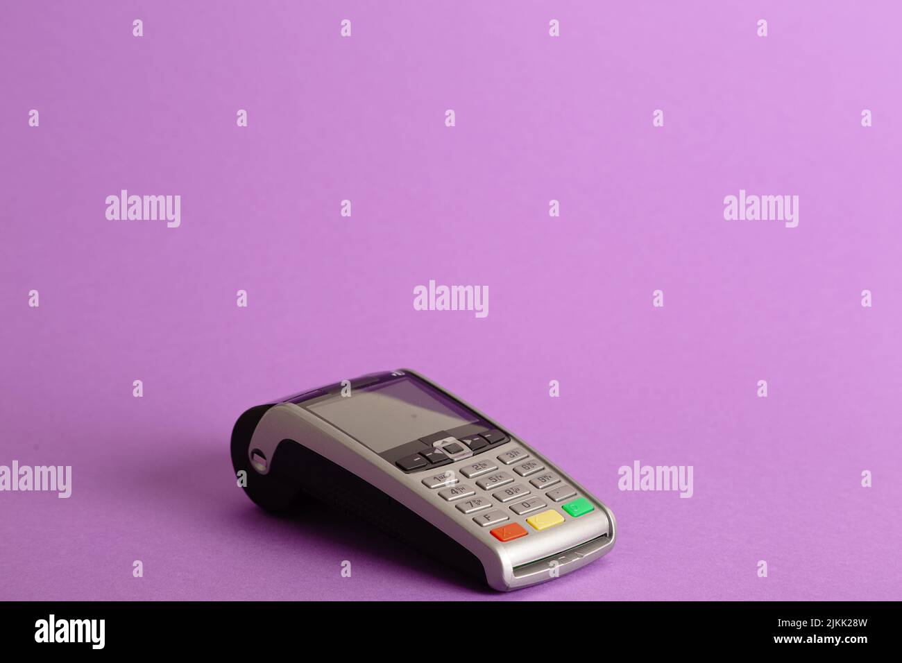 A closeup shot of the POS terminal credit card machine on a pink background Stock Photo