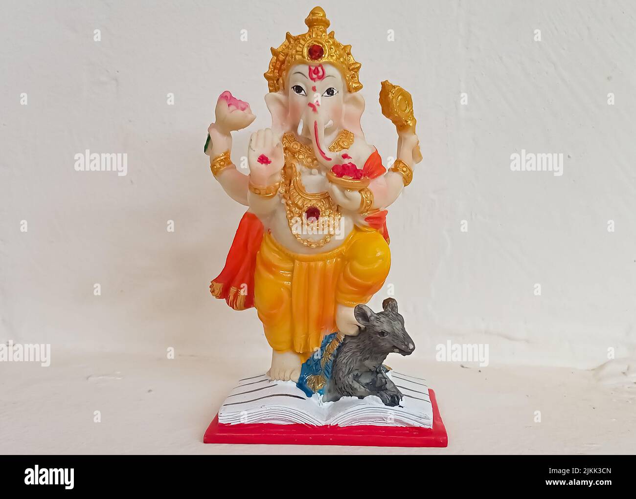 A closeup shot of the small sculpture of ganesh murti against white wall Stock Photo