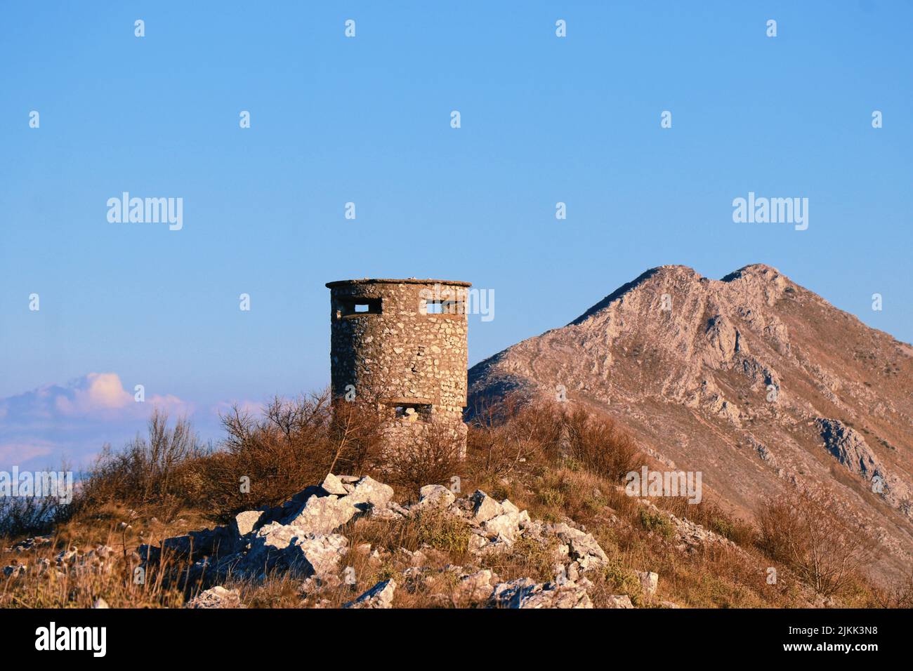 A shot of cembalo fortress over the rocky mountain under blue sky Stock Photo