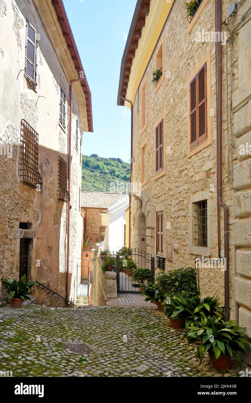 A vertical shot of a street between old medieval stone buildings in Italy. Stock Photo