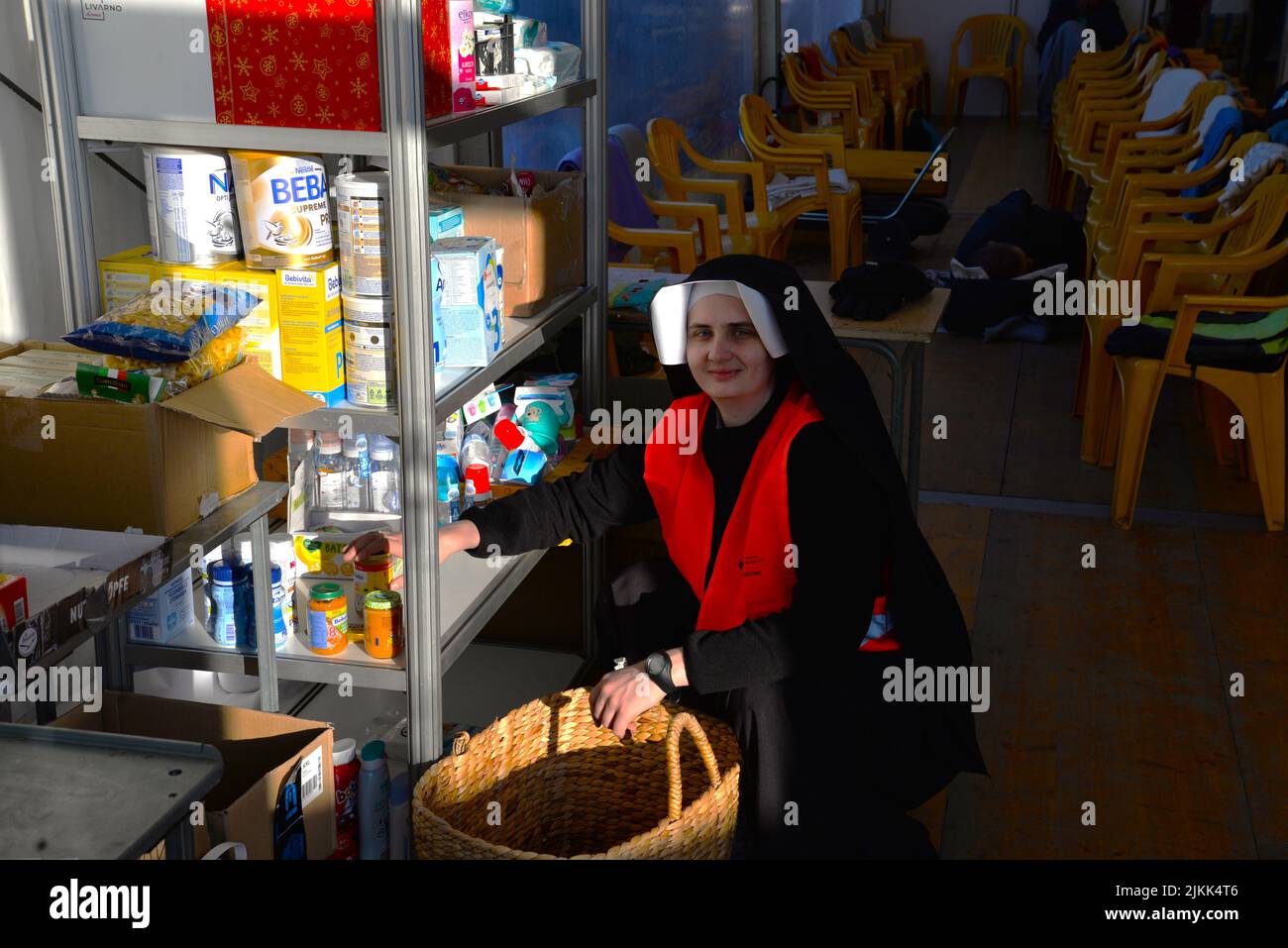 A nun restocks shelves at the welcome center in Poland for Ukrainian refugees at the border (Medyka, Poland) Stock Photo