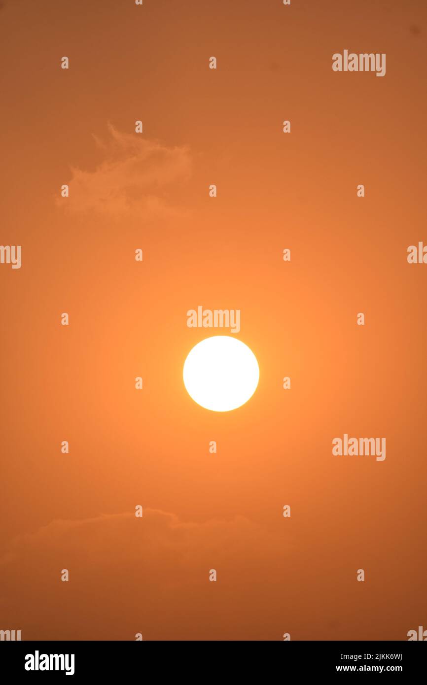 The glowing sun in an orange sky Stock Photo
