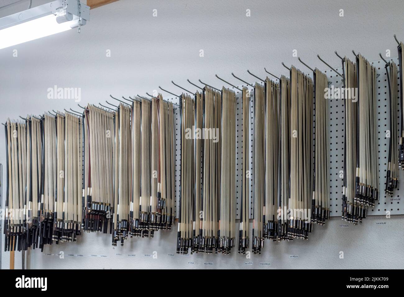 An array of strings for stringed musical instruments hanging on a wall