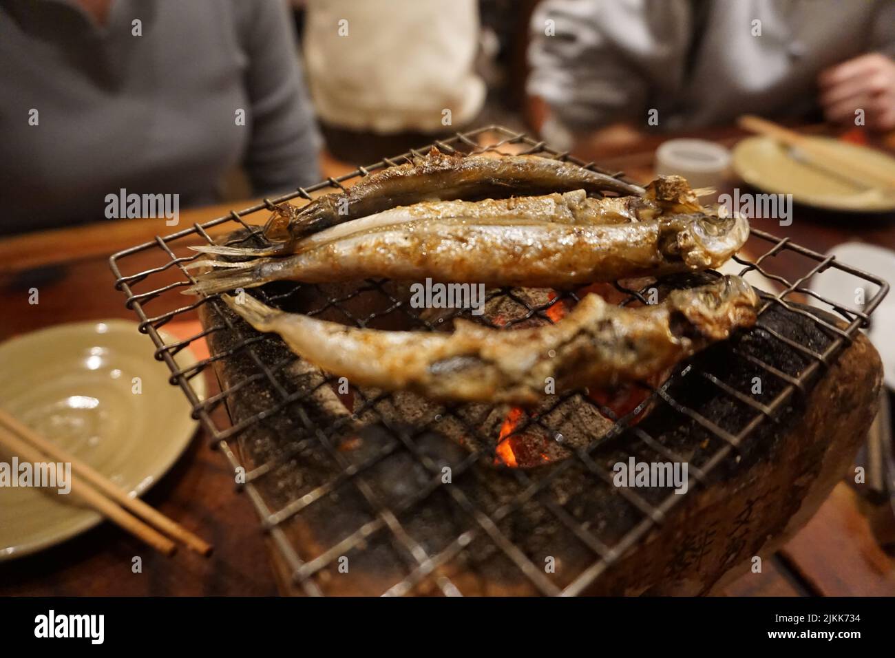 A soft focus of small fishes roasted over charcoal Stock Photo
