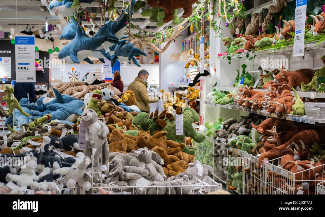 Moscow, Russia, February 2021: A bunch of soft toys on the shelves in an Ikea store: sharks, dinosaurs, bunnies, dogs. Toys on shelves, on the ceiling Stock Photo
