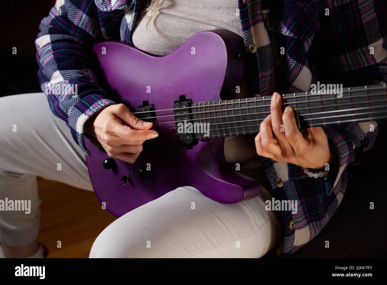 A person playing on a purple electronic guitar. Stock Photo