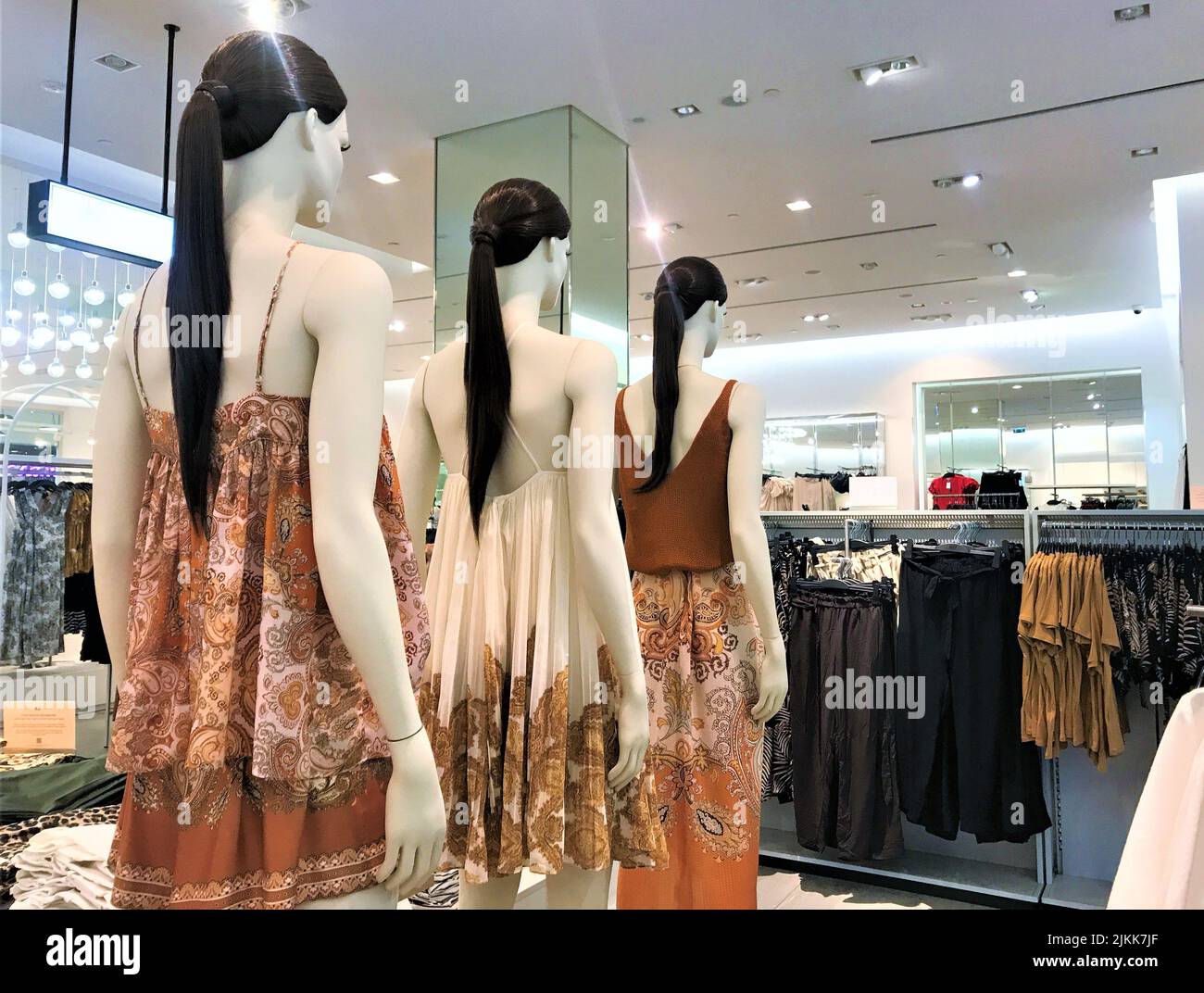 Moscow, Russia, June 2019: Female mannequins, brunettes with long hair and pony tail stand in line, one behind the other, dressed in beige Stock Photo