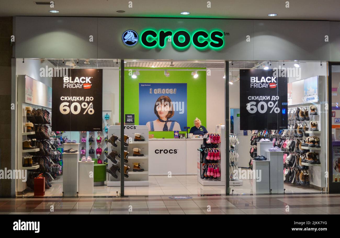Moscow, Russia, November 2019: Front view the shop Crocs, Inc. The entrance inside shopping Mall. Company logo. Outside black Friday sale posters Stock Photo -