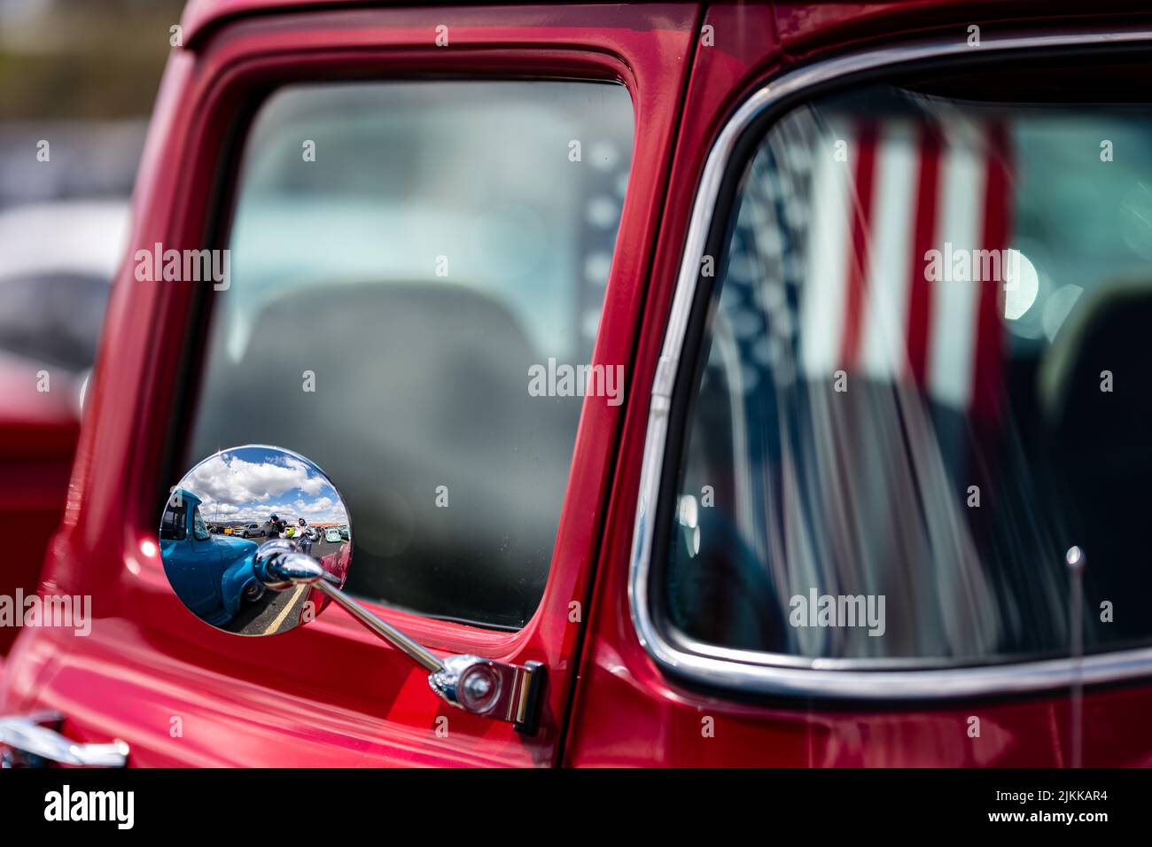 The United States flag inside Red pickup antique truck nearside mirror Stock Photo