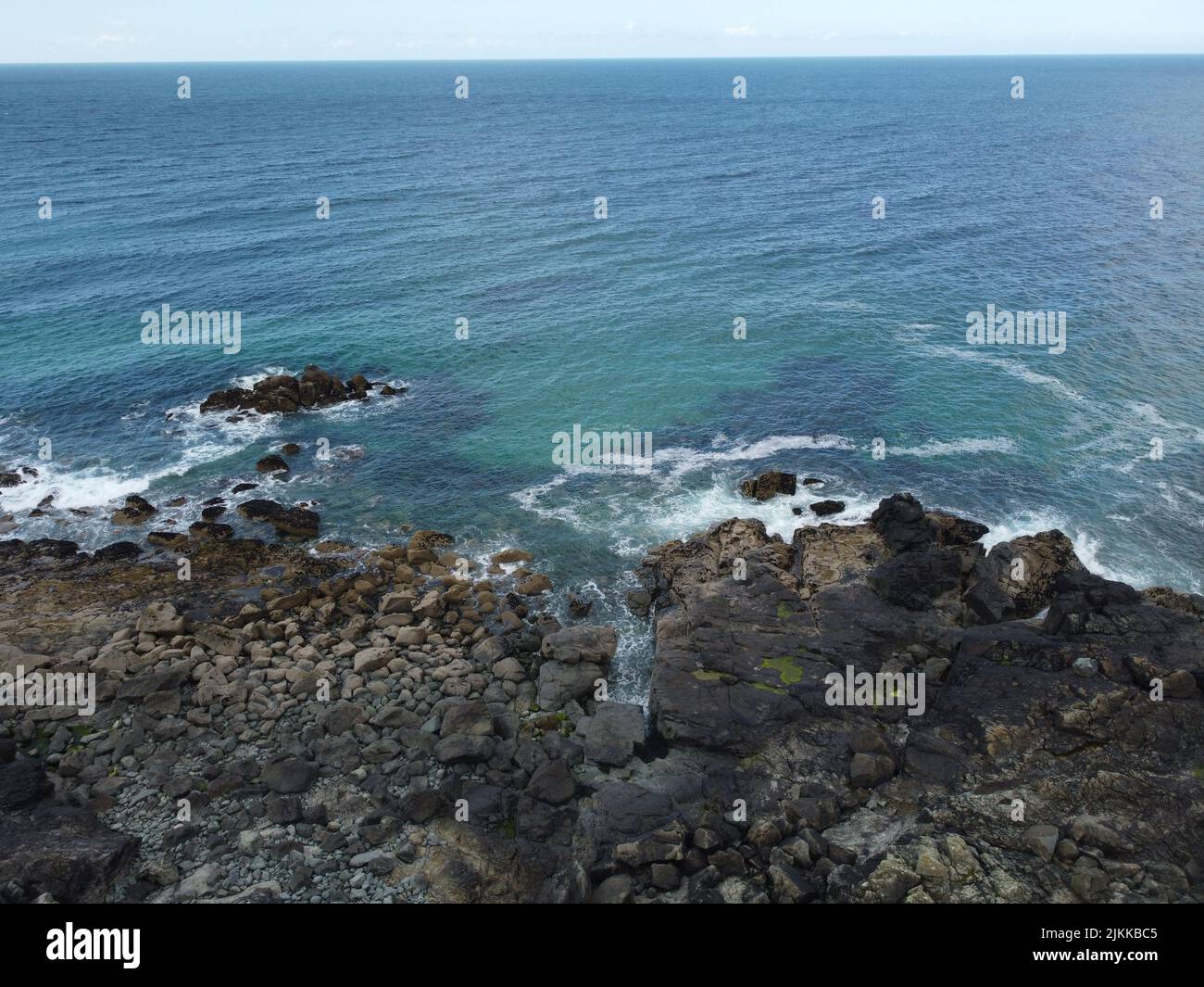 An aerial view of a blue ocean with a rocky beach Stock Photo - Alamy