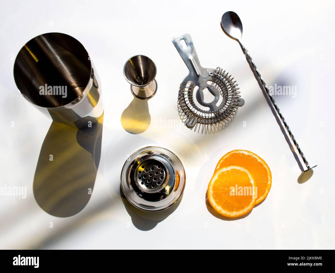 A top view of barware for making cocktails with orange slices on a white background Stock Photo