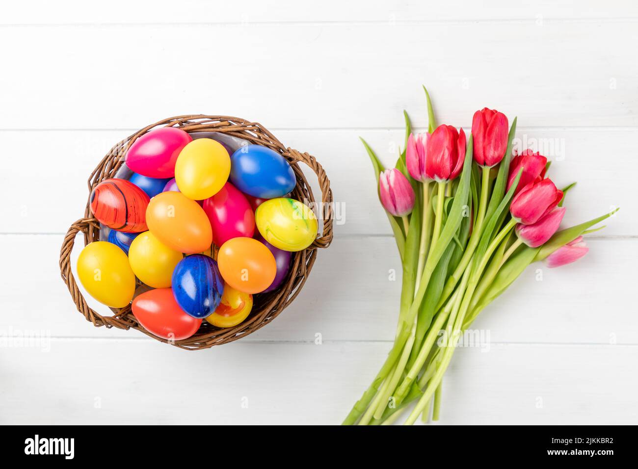 easter nest with colorful eggs and tulips on a white background Stock ...