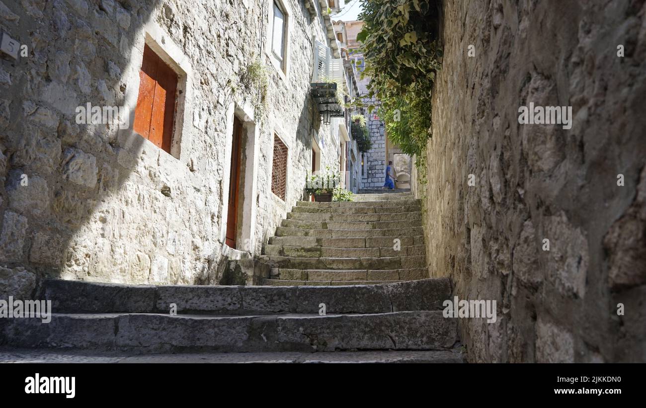 A shot of stone stairs going up to a backyard against old houses in Dubrovnik, Croatia Stock Photo