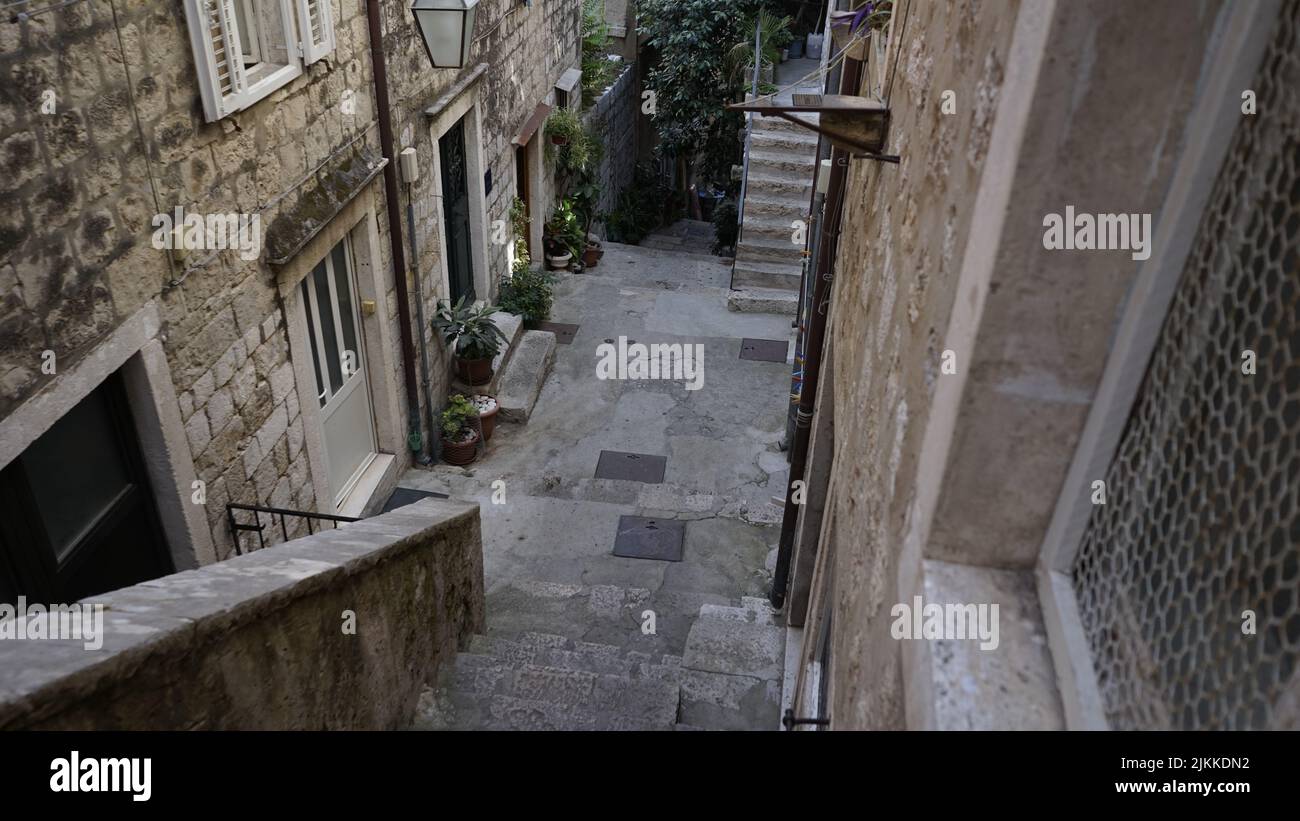 A high angle of stone stairs going down to a backyard against old houses in Dubrovnik, Croatia Stock Photo