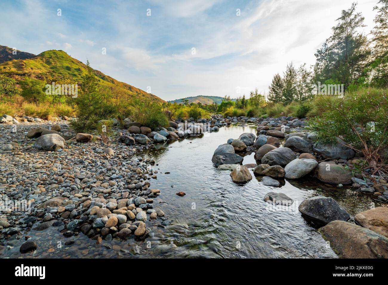 A scenic view of the river flowing through its rocky banks surrounded ...