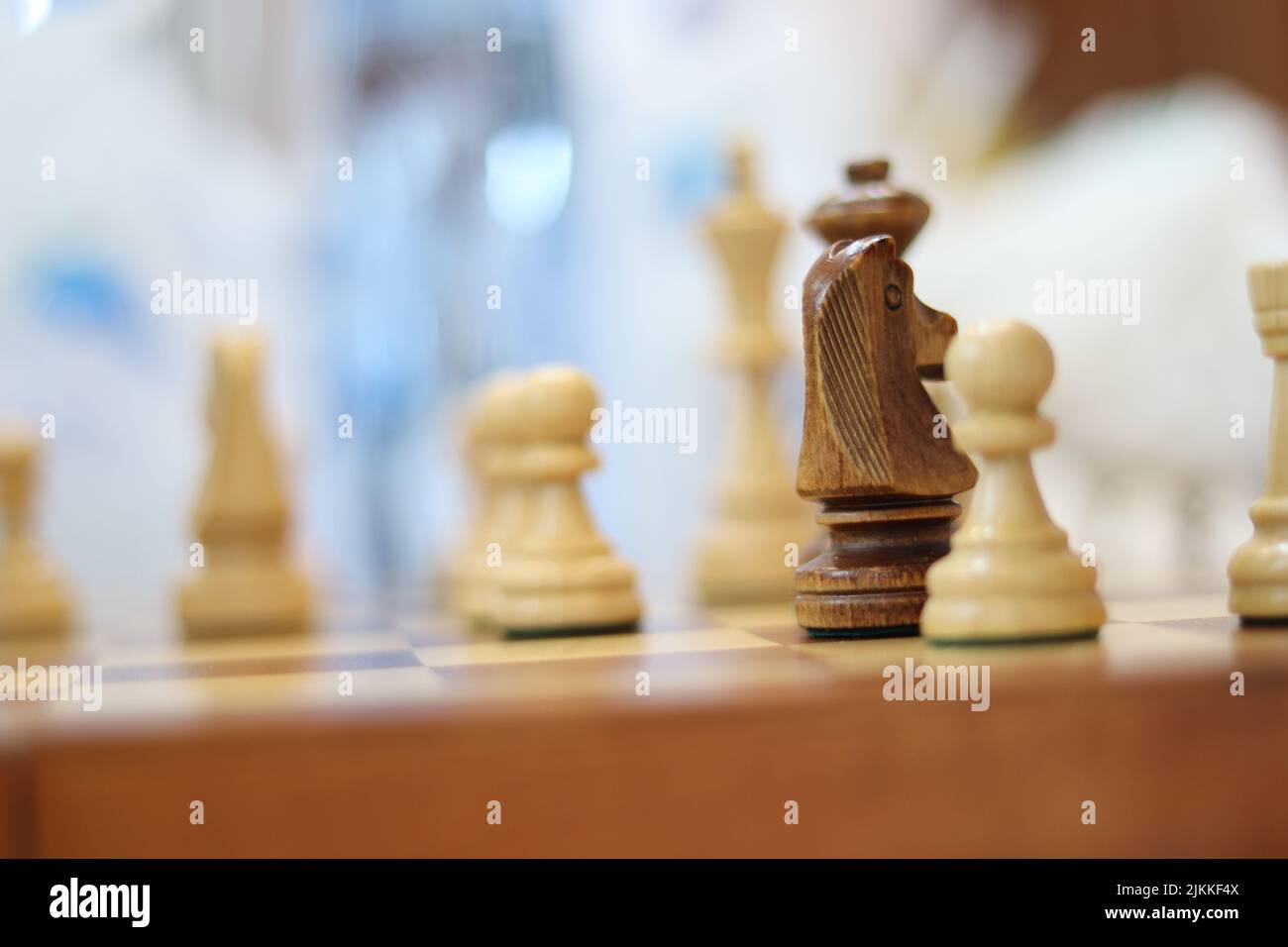 A selective focus shot of a chess knight piece next to pawn pieces Stock Photo