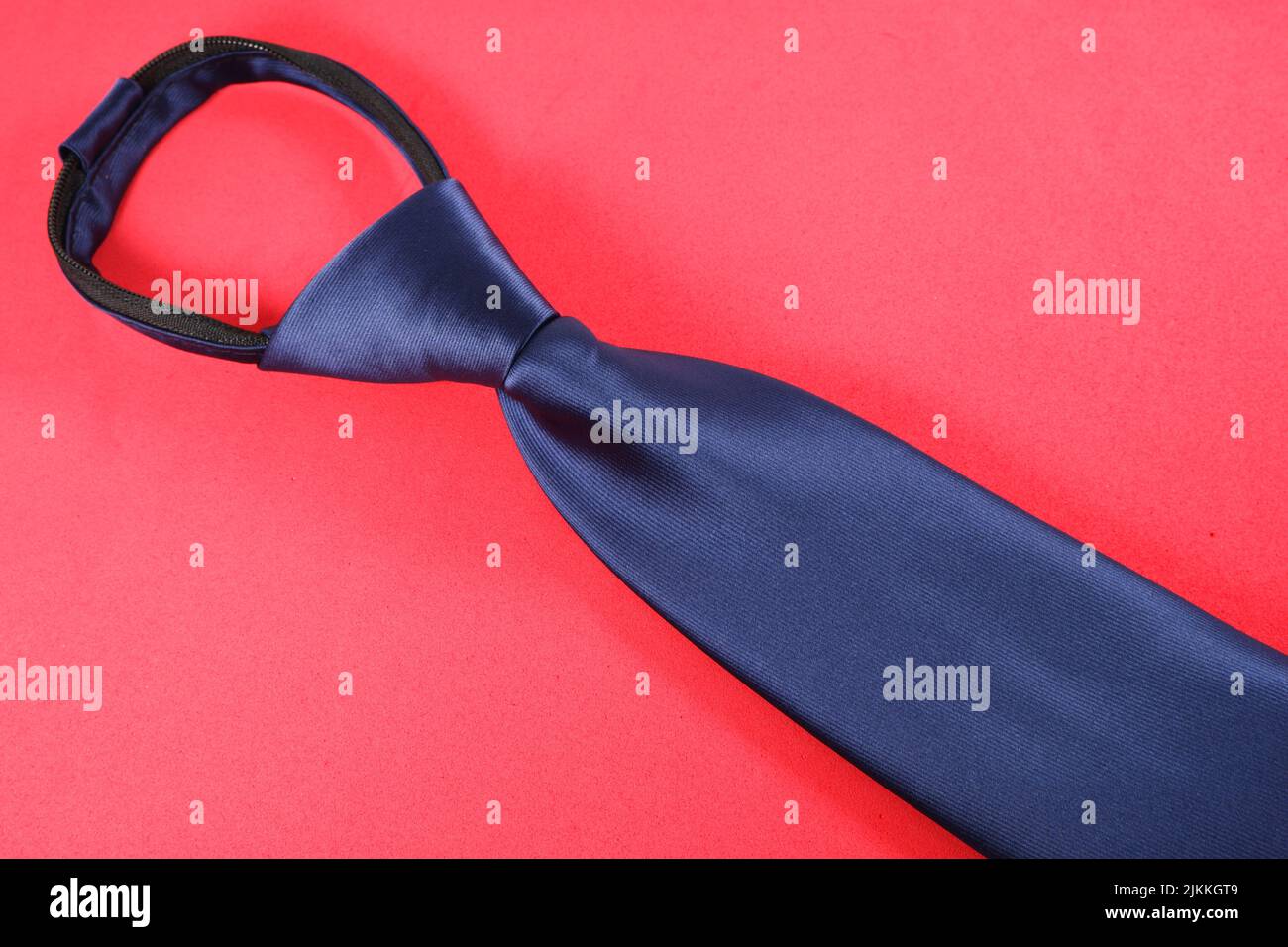 A blue necktie isolated on a red background Stock Photo