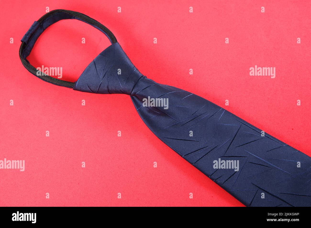 A blue necktie isolated on a red background Stock Photo