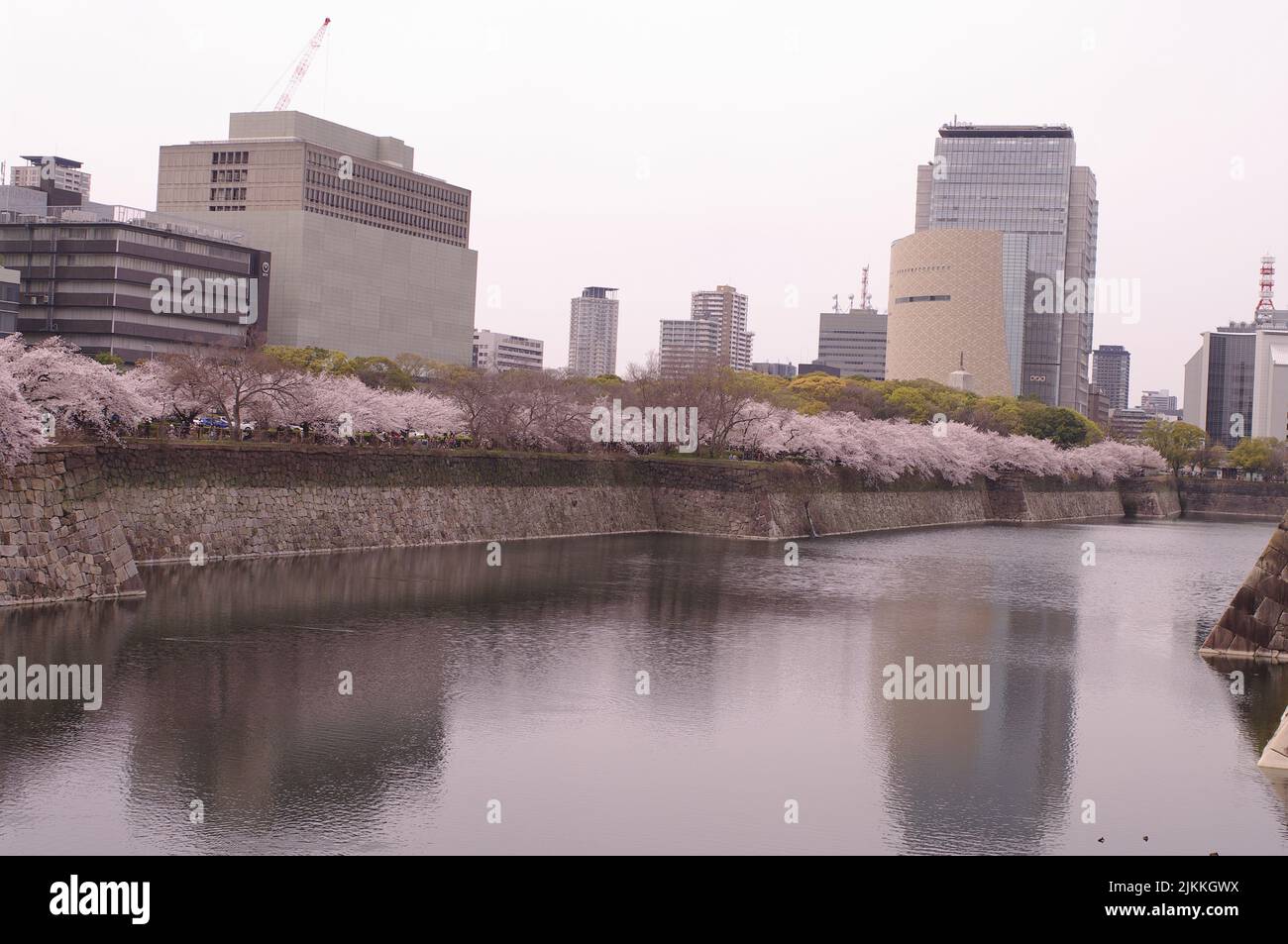 A beautiful view of a river and modern tall buildings under the cloudy sky Stock Photo