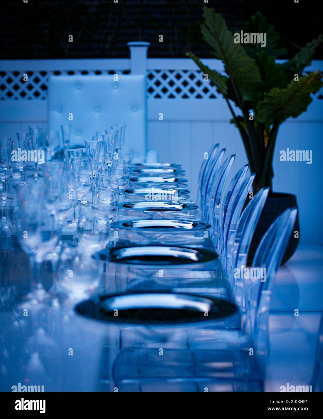 A vertical shot of a beautiful setting of a festive table illuminated in blue on the veranda Stock Photo