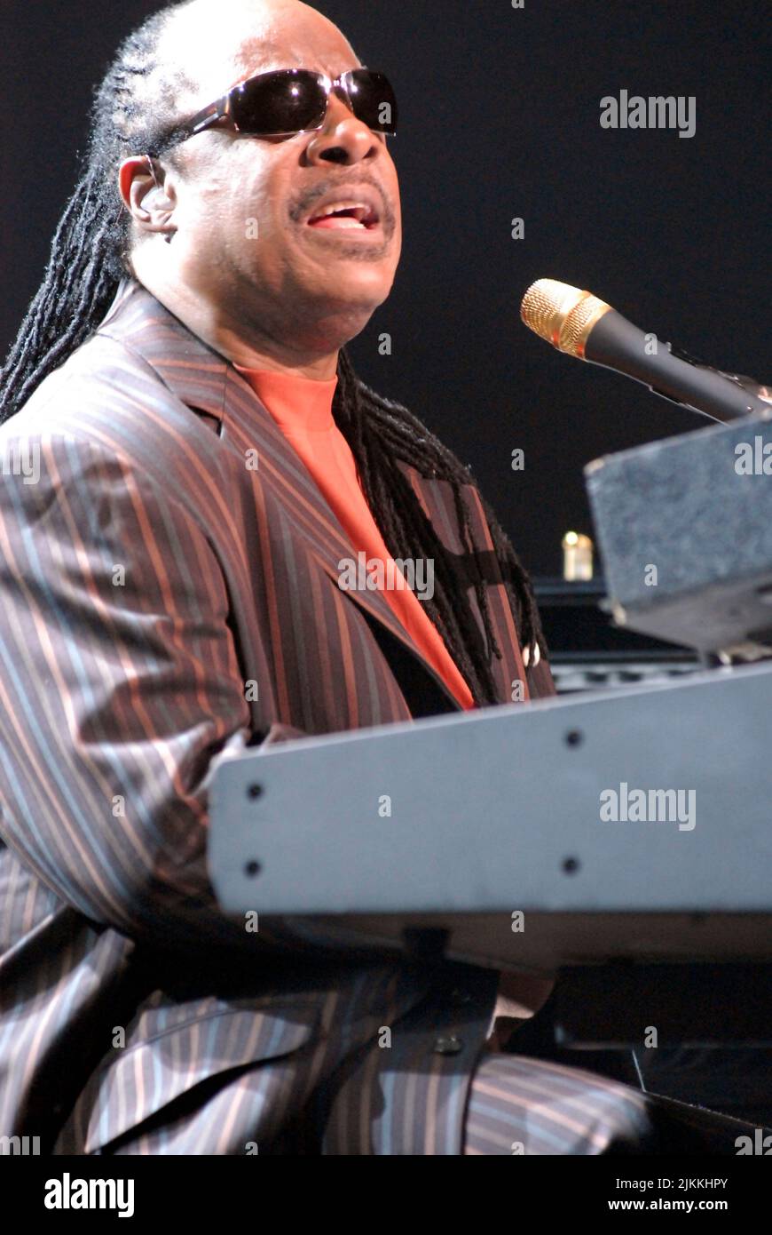 A vertical shot of legendary Stevie Wonder playing the piano and