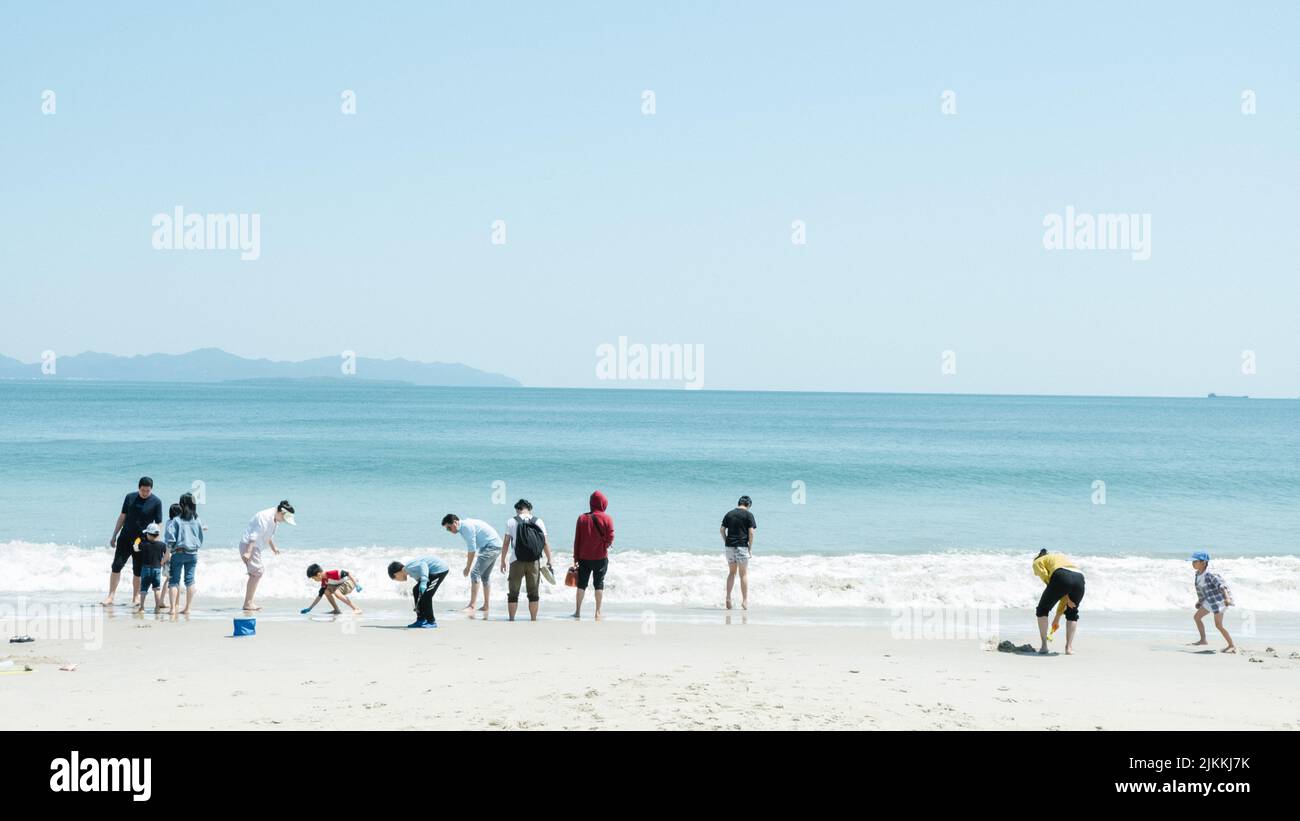 A beautiful beach in Shenzen with parents and their kids playing with sand in summer Stock Photo