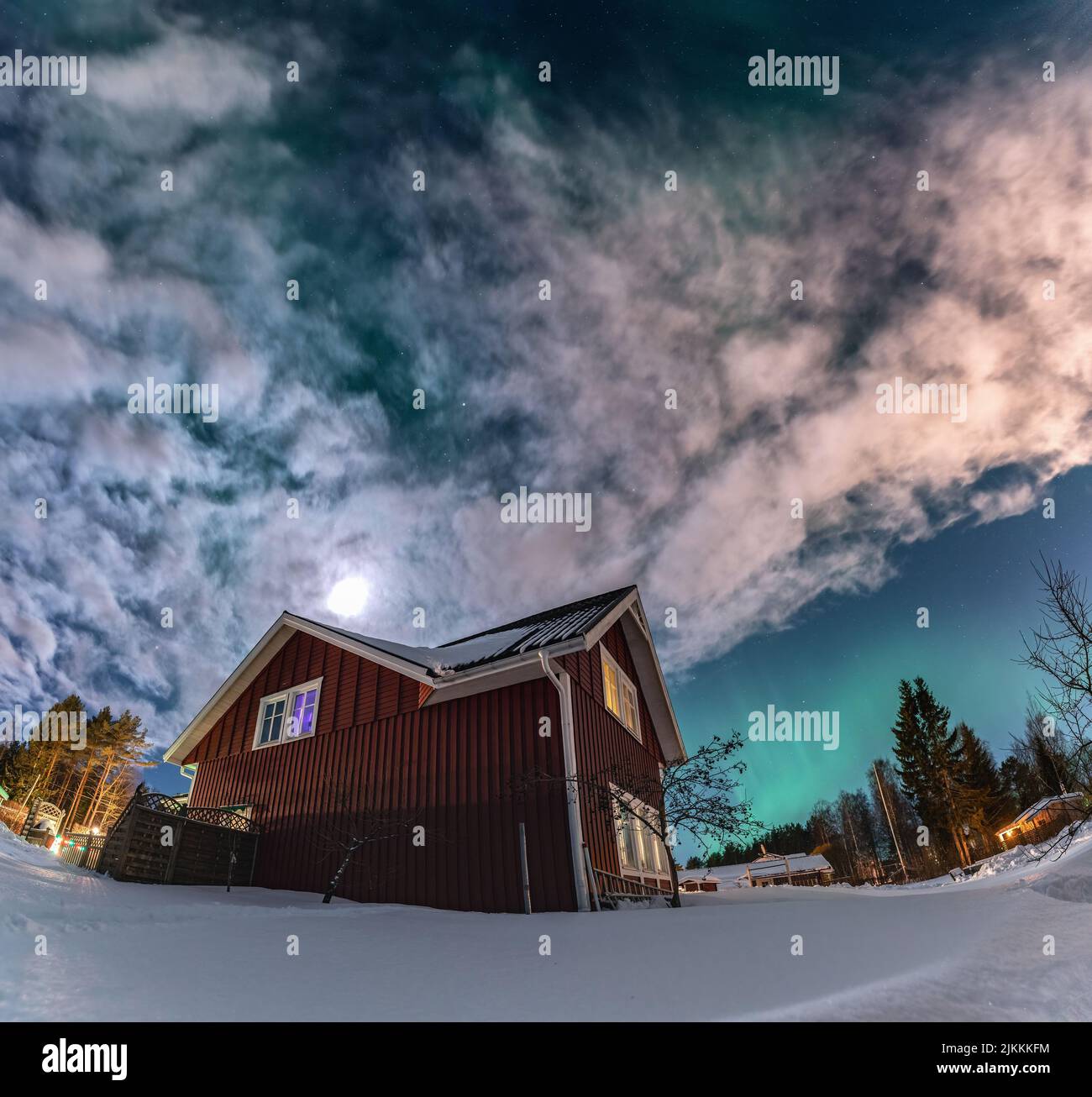 Fantastic Aurora Borealis winter landscape with wooden house.  Northern light in night sky. Christmas holiday and winter vacation, sky green lights Stock Photo