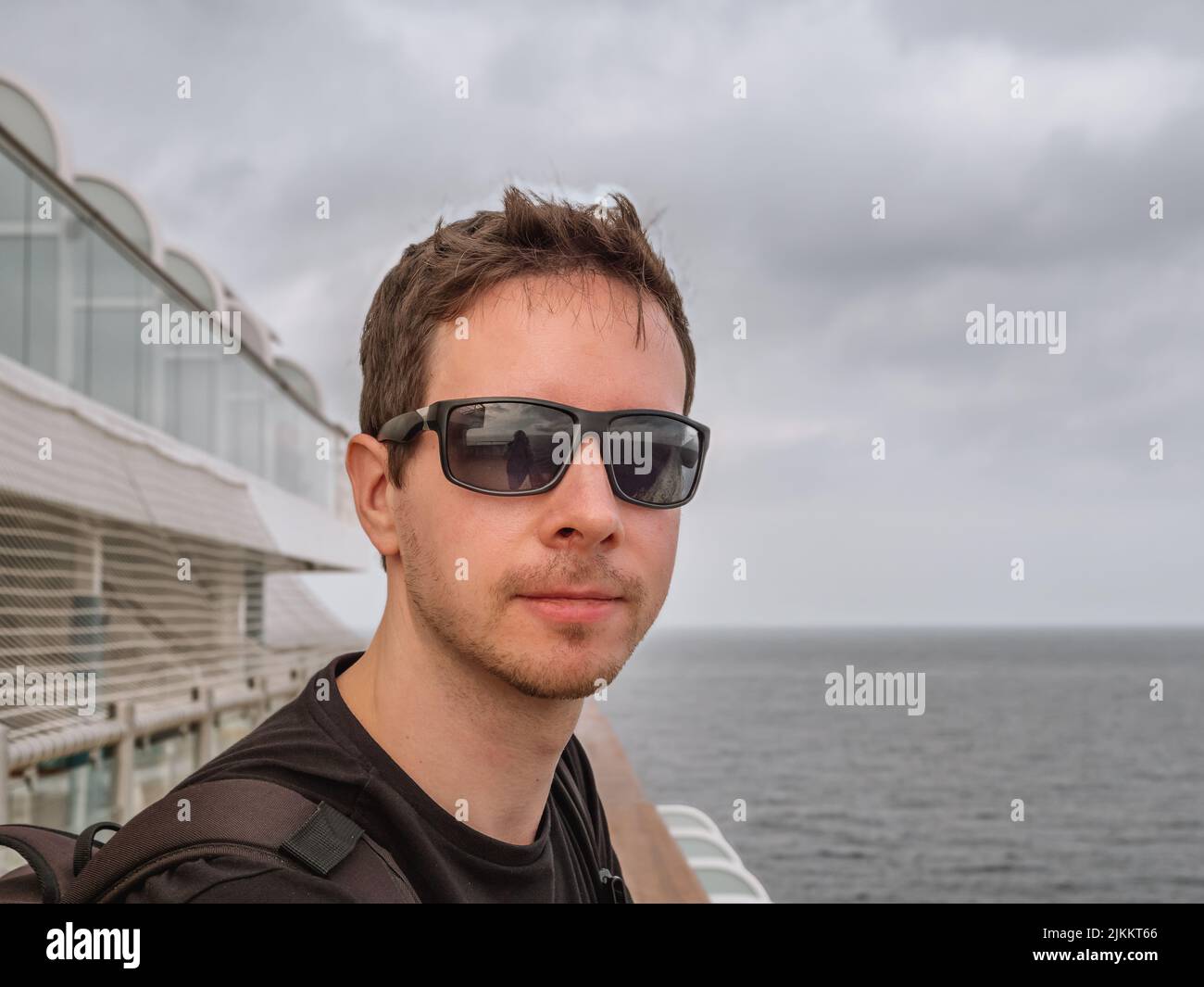 A closeup of a man on a cruise ship with the ocean in the background Stock Photo