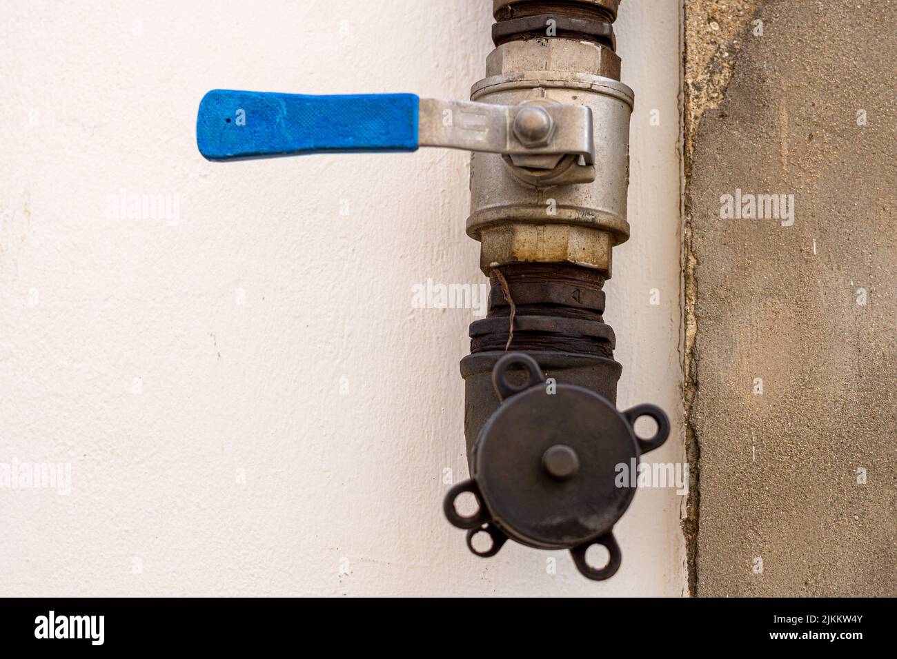 The Old valve stopcock with the blue pipe. Stock Photo
