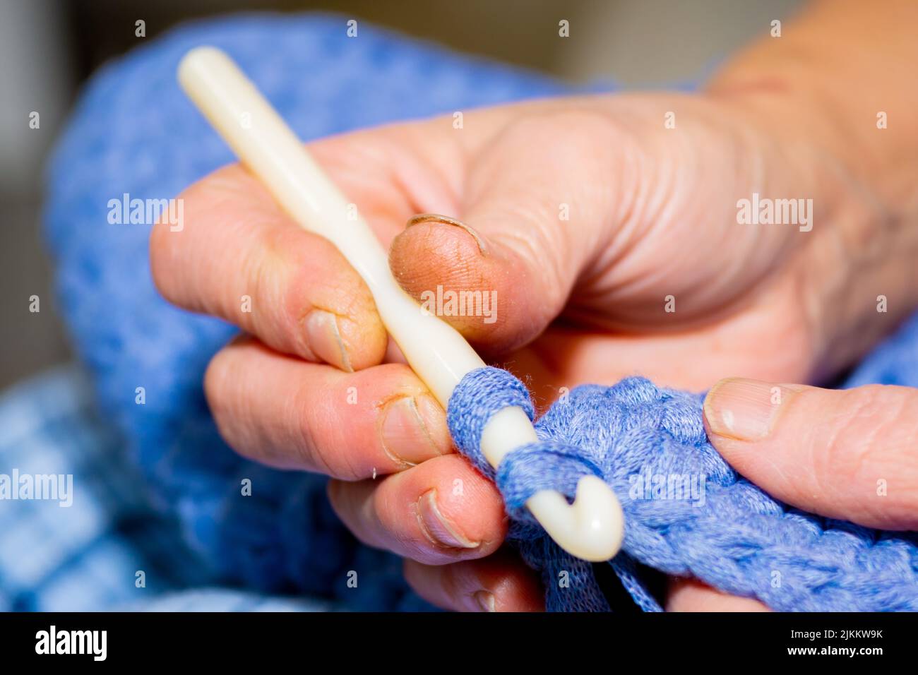 Old woman a woman knitting crochet with blue yarn Stock Photo - Alamy