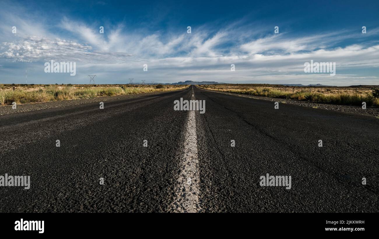 An empty asphalt road under a cloudy sky Stock Photo