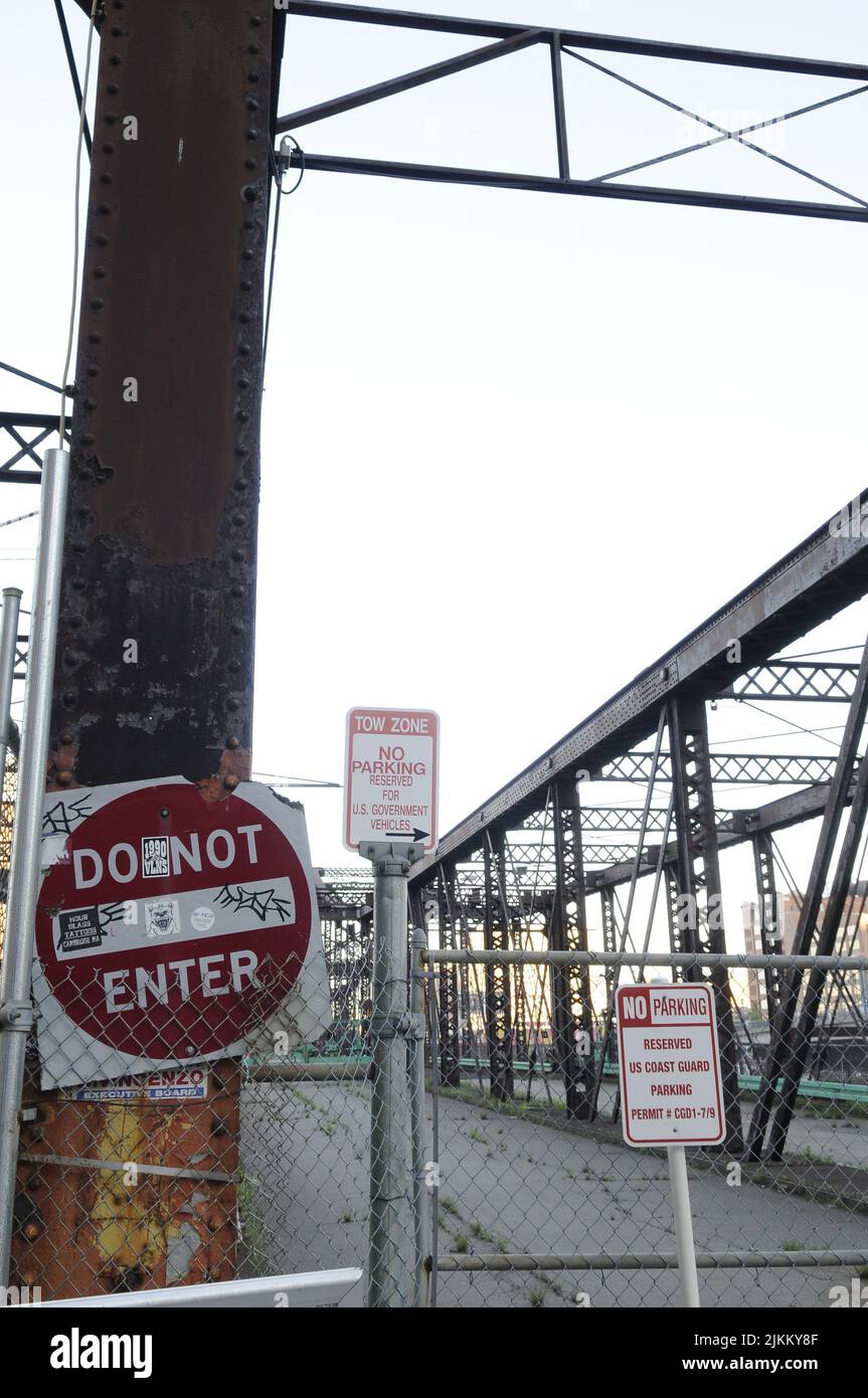 A vertical shot of an old, unusable, iron bridge with warning signs ...