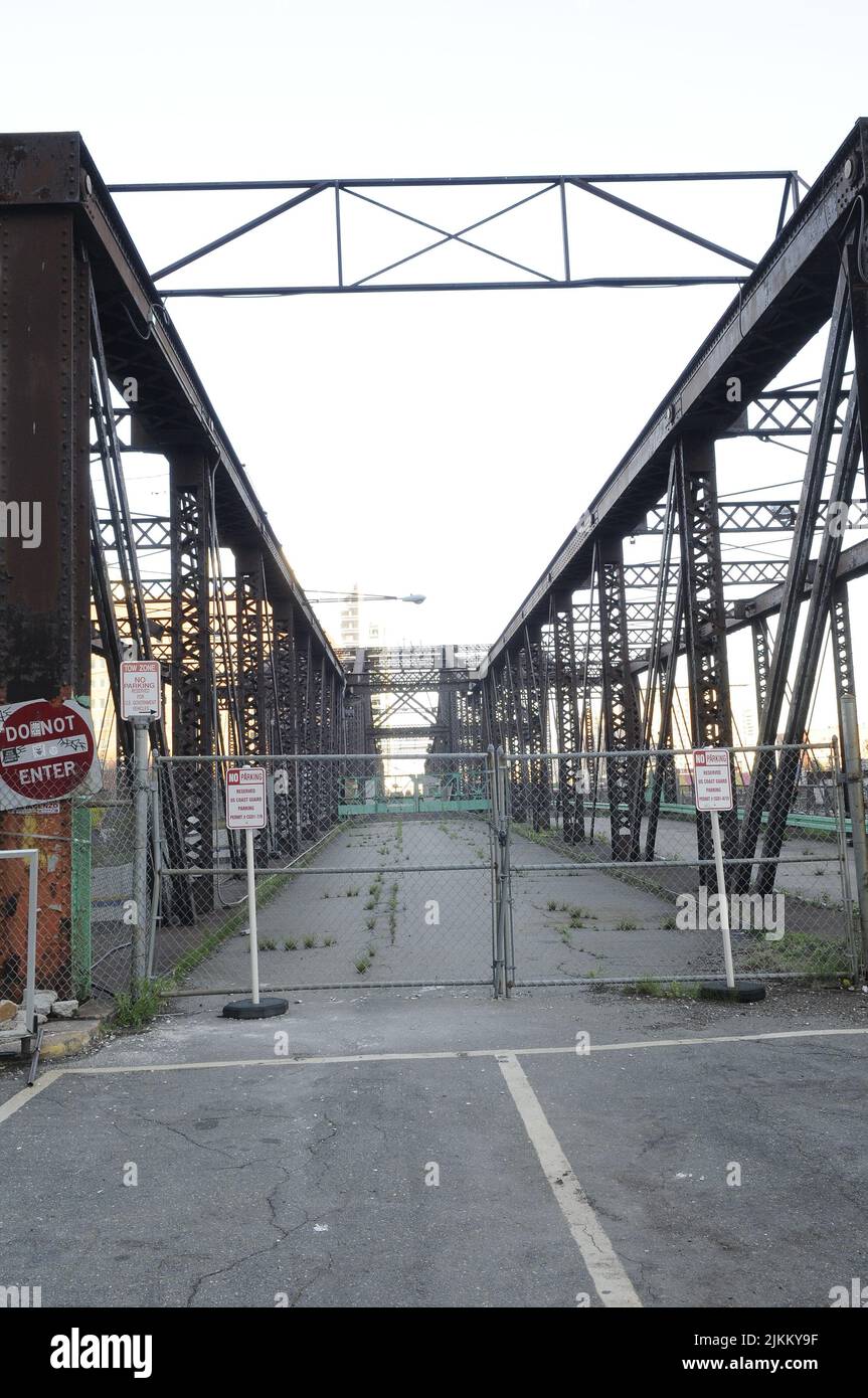 A vertical shot of an old, unusable, metal bridge with warning signs Stock Photo