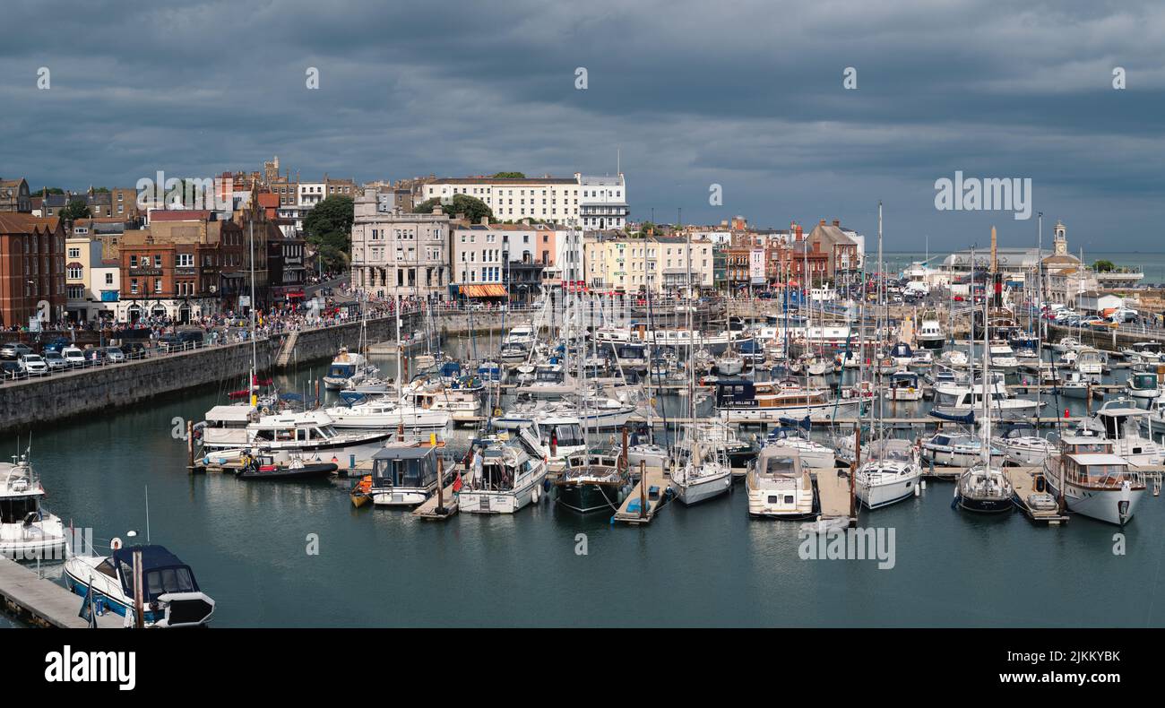 Ramsgate, England - July 31 2022 Panoramic image of the historic Royal Harbour on a cloudy summer day. The town was celebrating its carnival day. Stock Photo