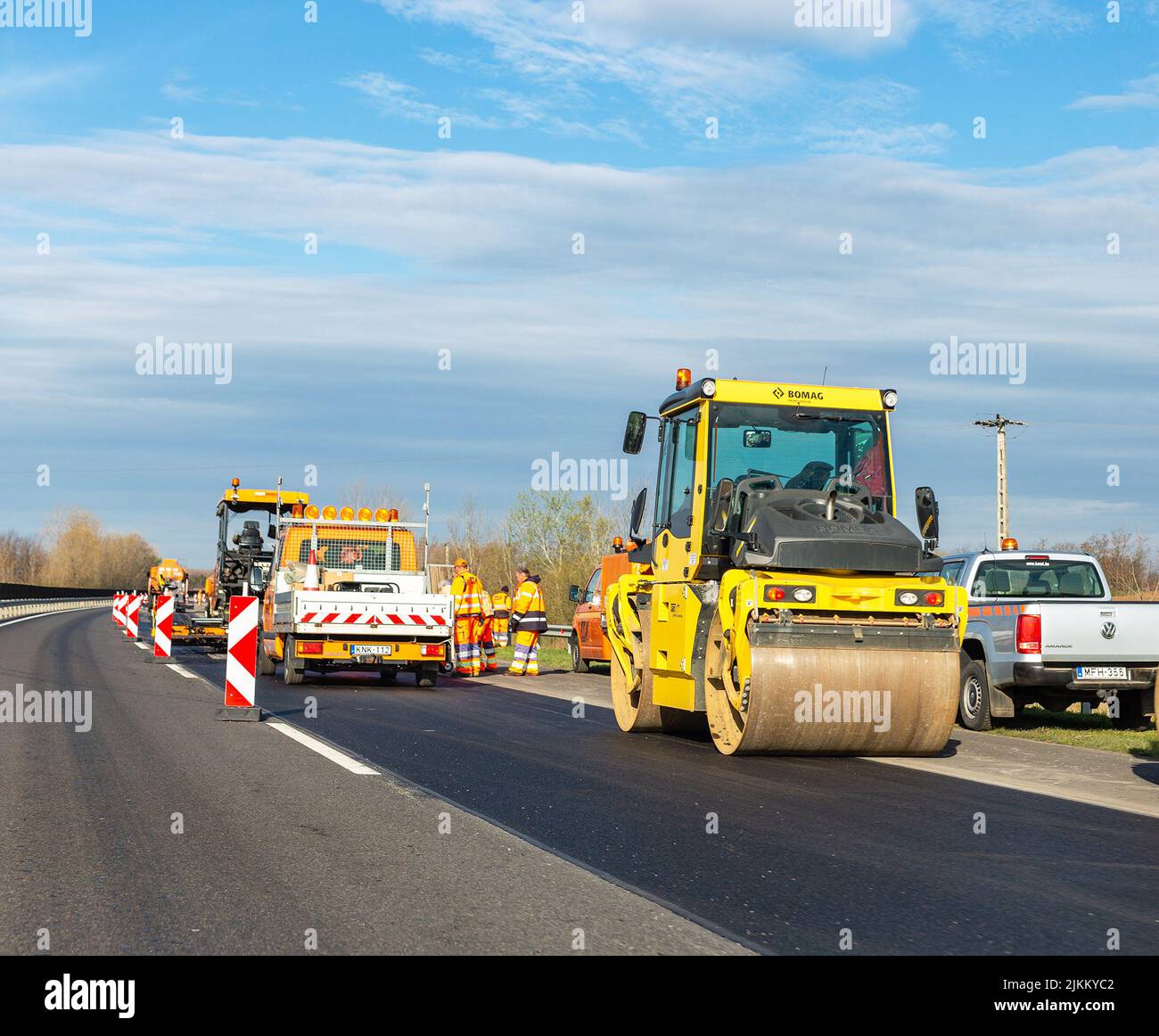 Nyiregyhaza, Hungary – December 12, 2021: Road works on highway. Asphalt roller Bomag and other equipment Stock Photo