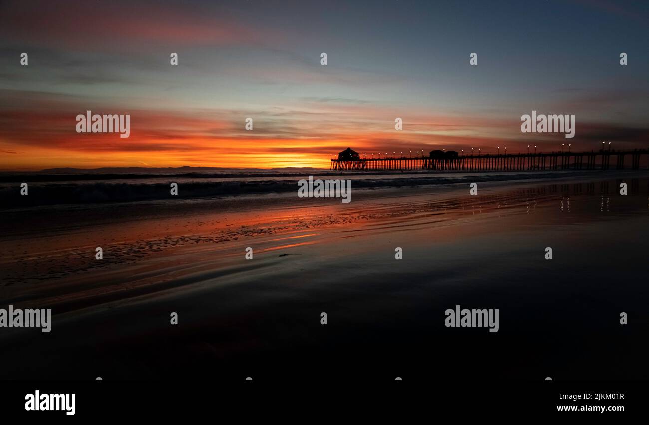 A beautiful Sunset on Huntington Beach with bridge in the background in California Stock Photo