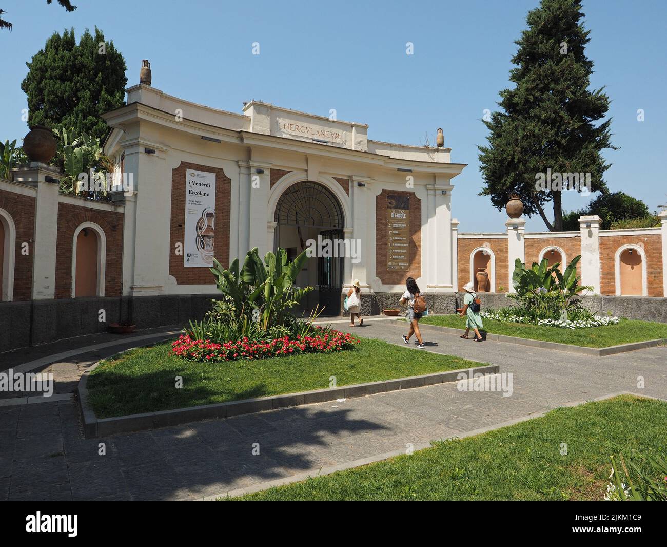 Entrance to the Herculaneum excavation site in. Ercolano, Campania, Italy, with three tourists visiting the site Stock Photo