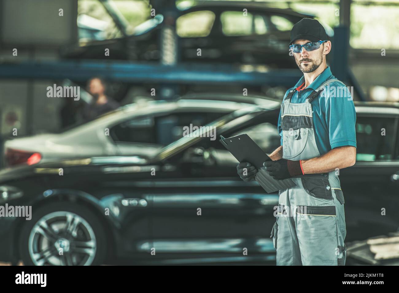 Caucasian Automotive Dealership Technician Performing Car Maintenance. Car Service Theme. Stock Photo
