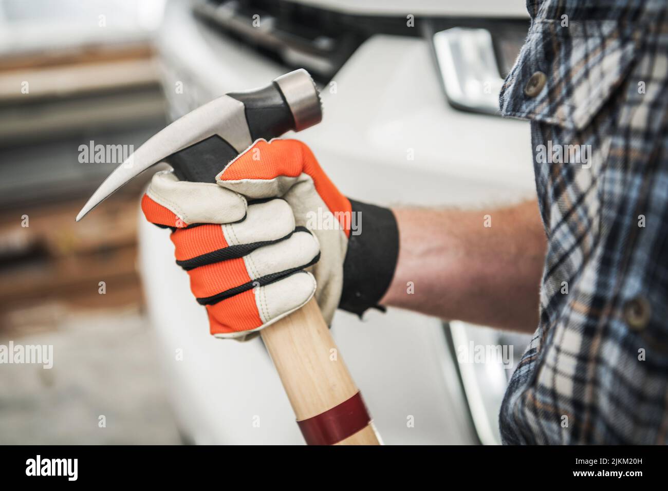 Industrial Theme. Large Hammer in Contractor's Hand. Men Wearing Safety