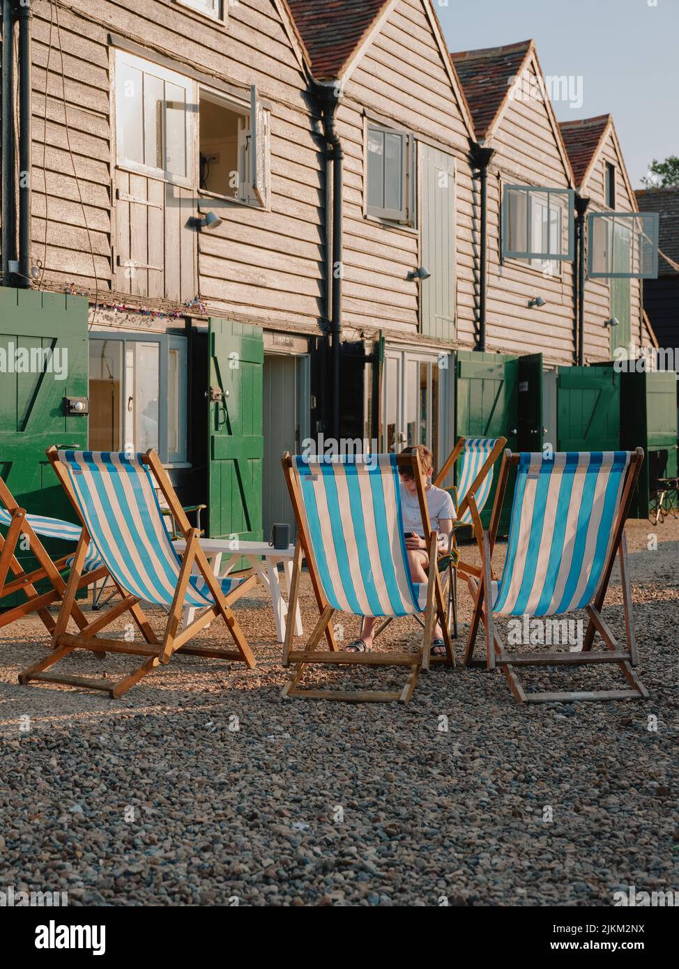 Summer deckchairs and the holiday let fisherman  huts on the seafront at Whitstable Kent England UK Stock Photo