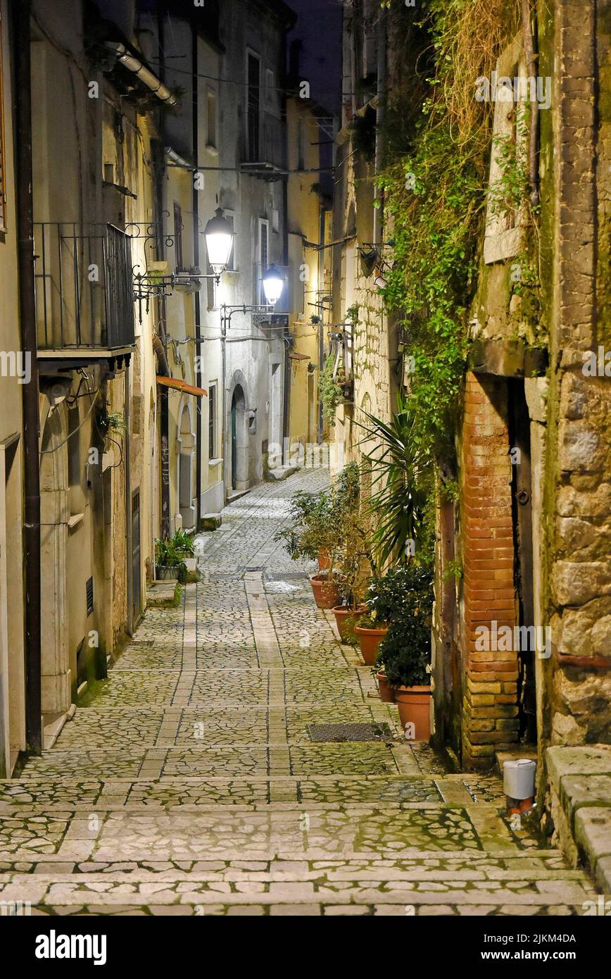 A vertical shot of a narrow street between old buildings in a village ...