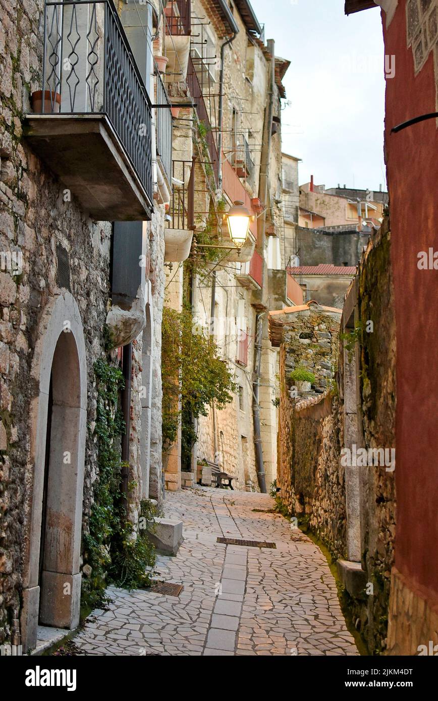 A vertical shot of a narrow street between old buildings in a village ...