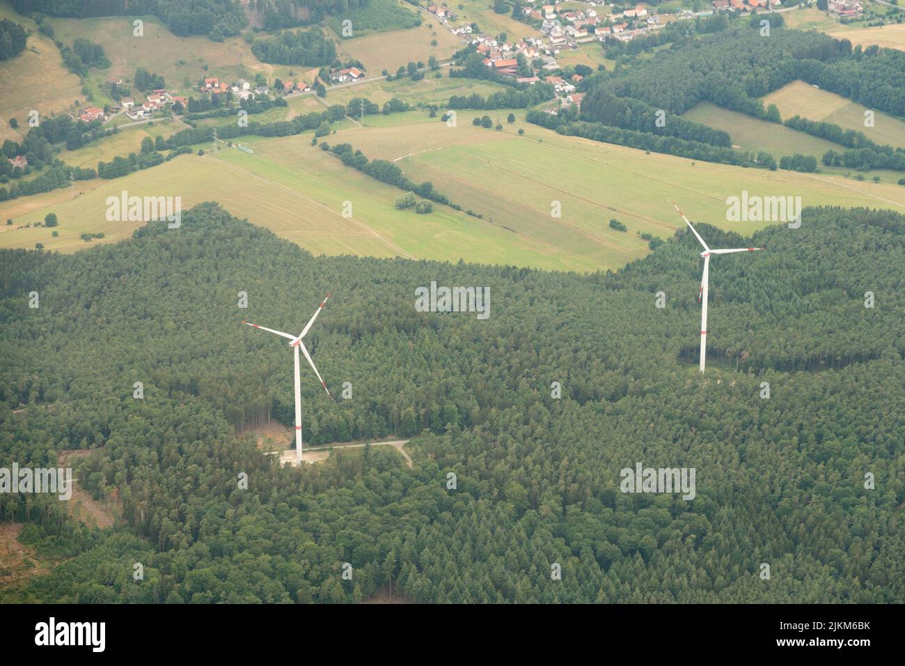 Michelstadt, Hesse, Germany, July 10, 2022 Wind energy turbines in a green forest seen from above Stock Photo