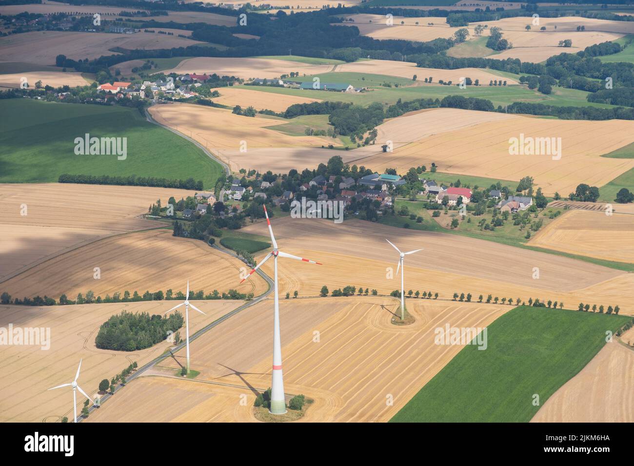 Doebeln, Saxony, Germany, July 11, 2022 Wind energy stations are rotating on a meadow seen from a small plane Stock Photo