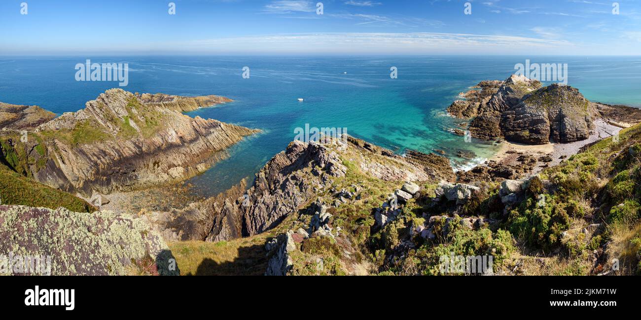 Panoramic view of the spectacular sandstone cliffs of Cape Erquy and the emerald sea. Stock Photo