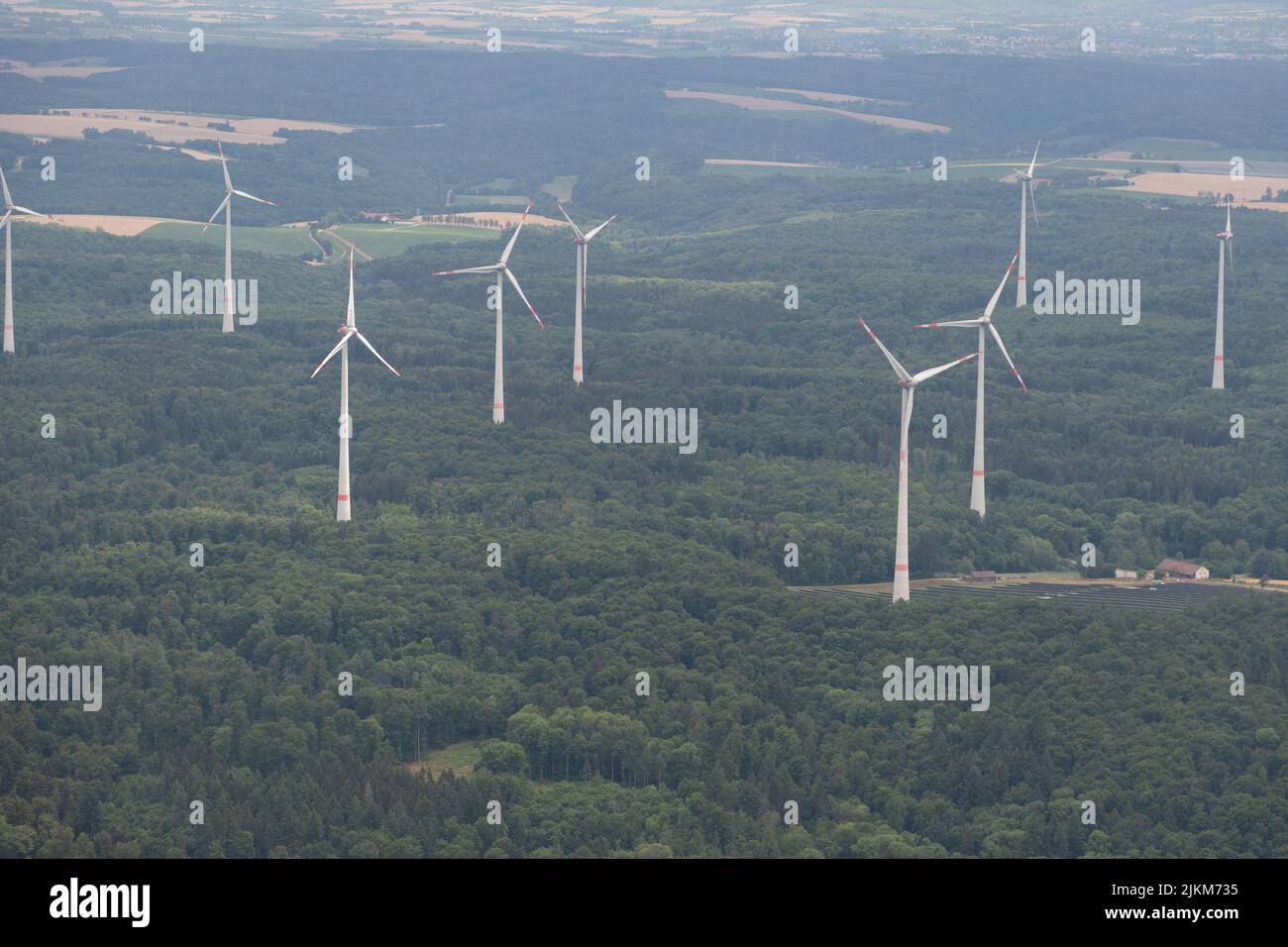 Moeckmuehl, Wurttemberg, Germany, July 11, 2022 Wind energy stations in a green forest seen from a small plane Stock Photo