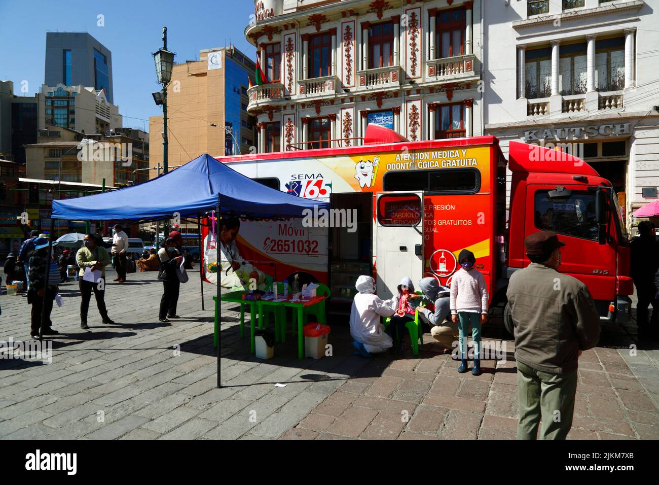 La Paz, Bolivia. 2nd August 2022. A doctor examines a child outside a mobile health clinic offering free health and dental checks / consultations. The service is organised by the La Paz city authorities in Plaza San Francisco in the city centre. SEMA165 (on the side of the truck) is the Municipal Ambulance Service (Servicio Municipal de Ambulancias) Stock Photo